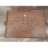 AN OAK BRASS HANDLED TRAY RELIEF CARVED WITH AN OVAL OF TWO MYTHICAL BEASTS WITHIN FISH SCALE CHIP