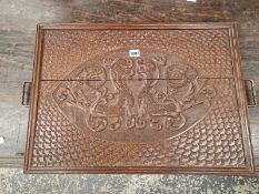 AN OAK BRASS HANDLED TRAY RELIEF CARVED WITH AN OVAL OF TWO MYTHICAL BEASTS WITHIN FISH SCALE CHIP