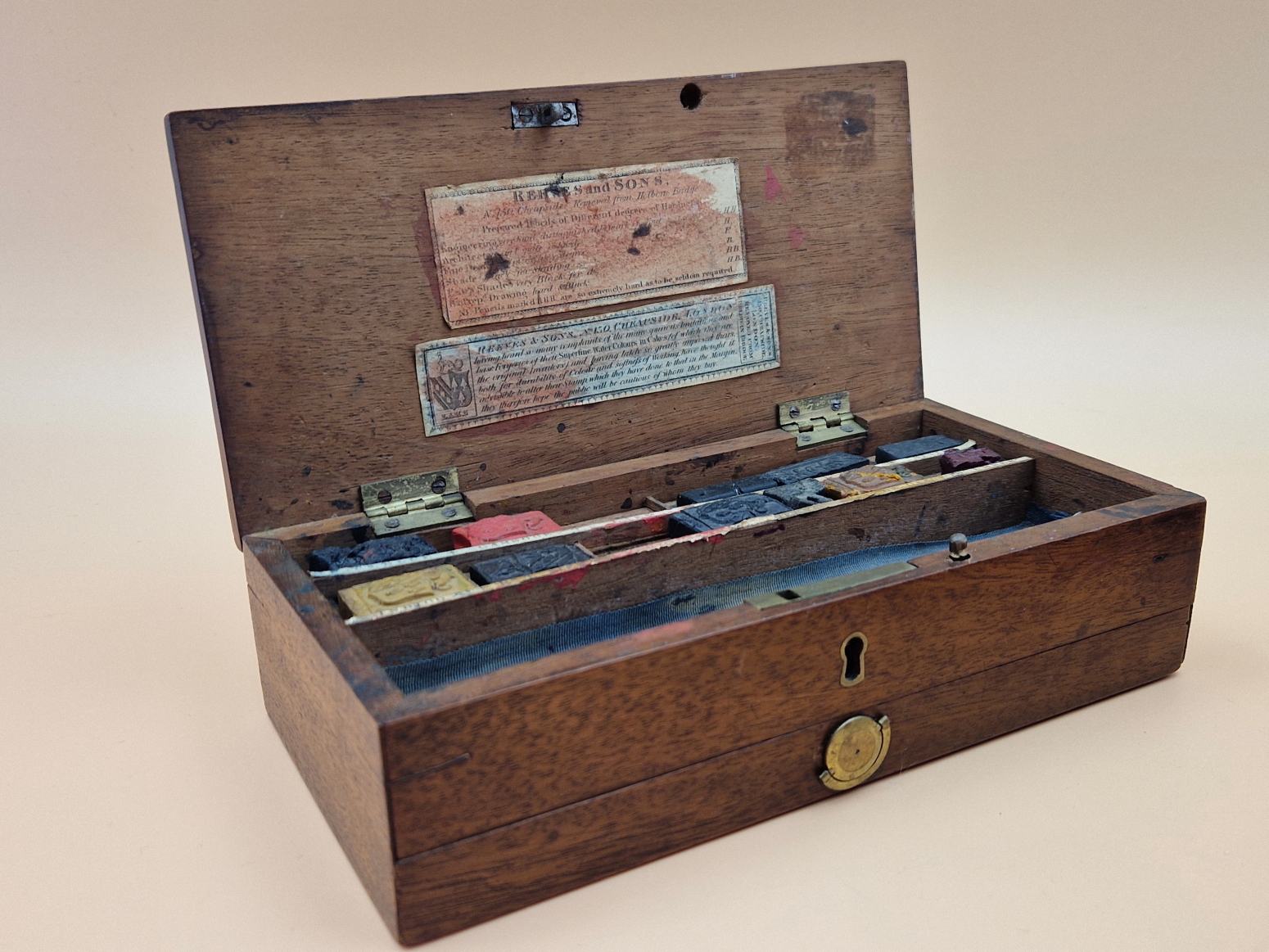 A LATE 19th C. REEVES MAHOGANY PAINT BOX CONTAINING SOME BLOCKS OF UNUSED PAINT AND CERAMIC PALETTES