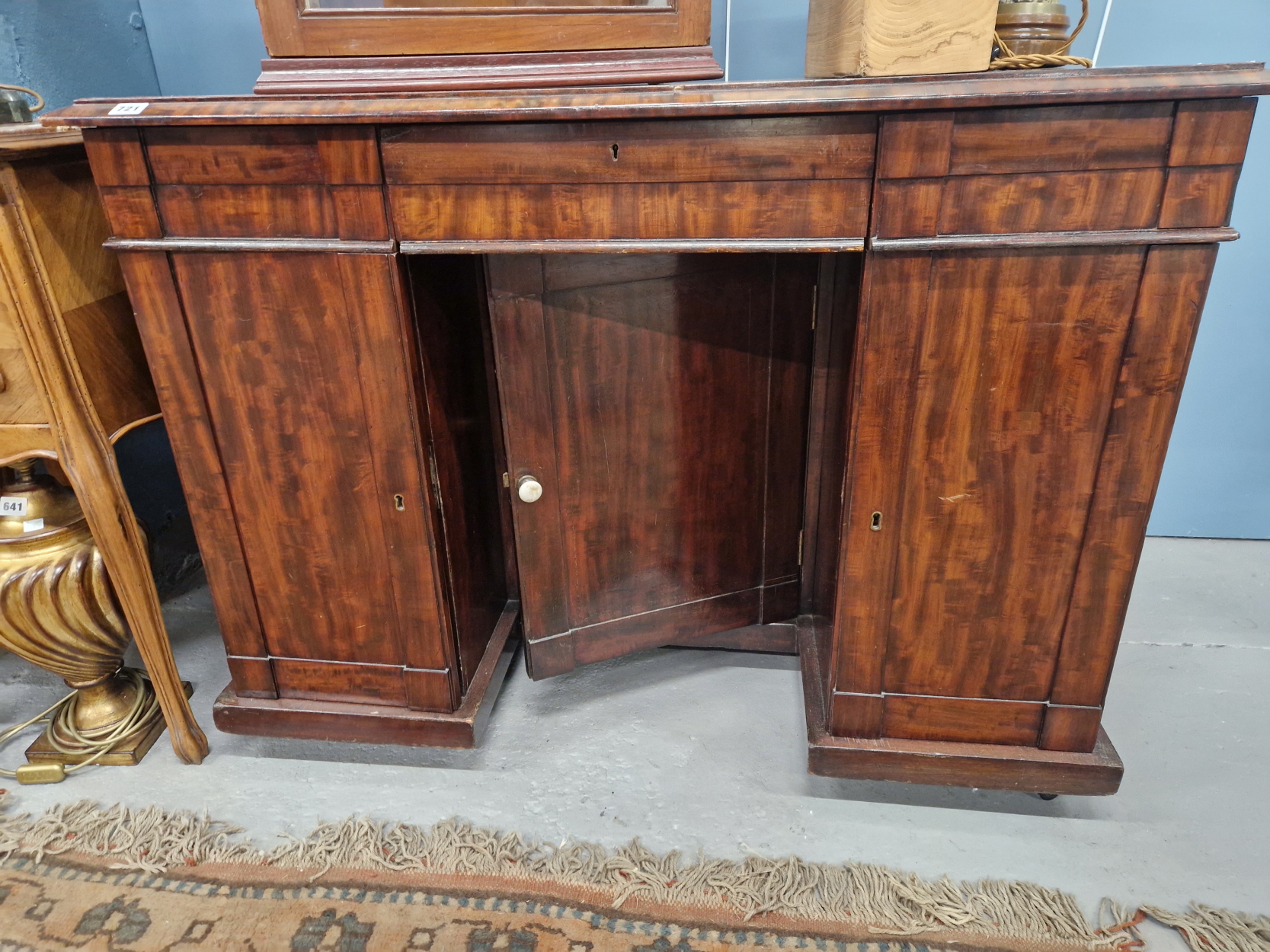 A 19th C. MAHOGANY PEDESTAL DESK WITH THREE APRON DRAWERS OVER A CENTRAL RECESSED CUPBOARD FLANKED