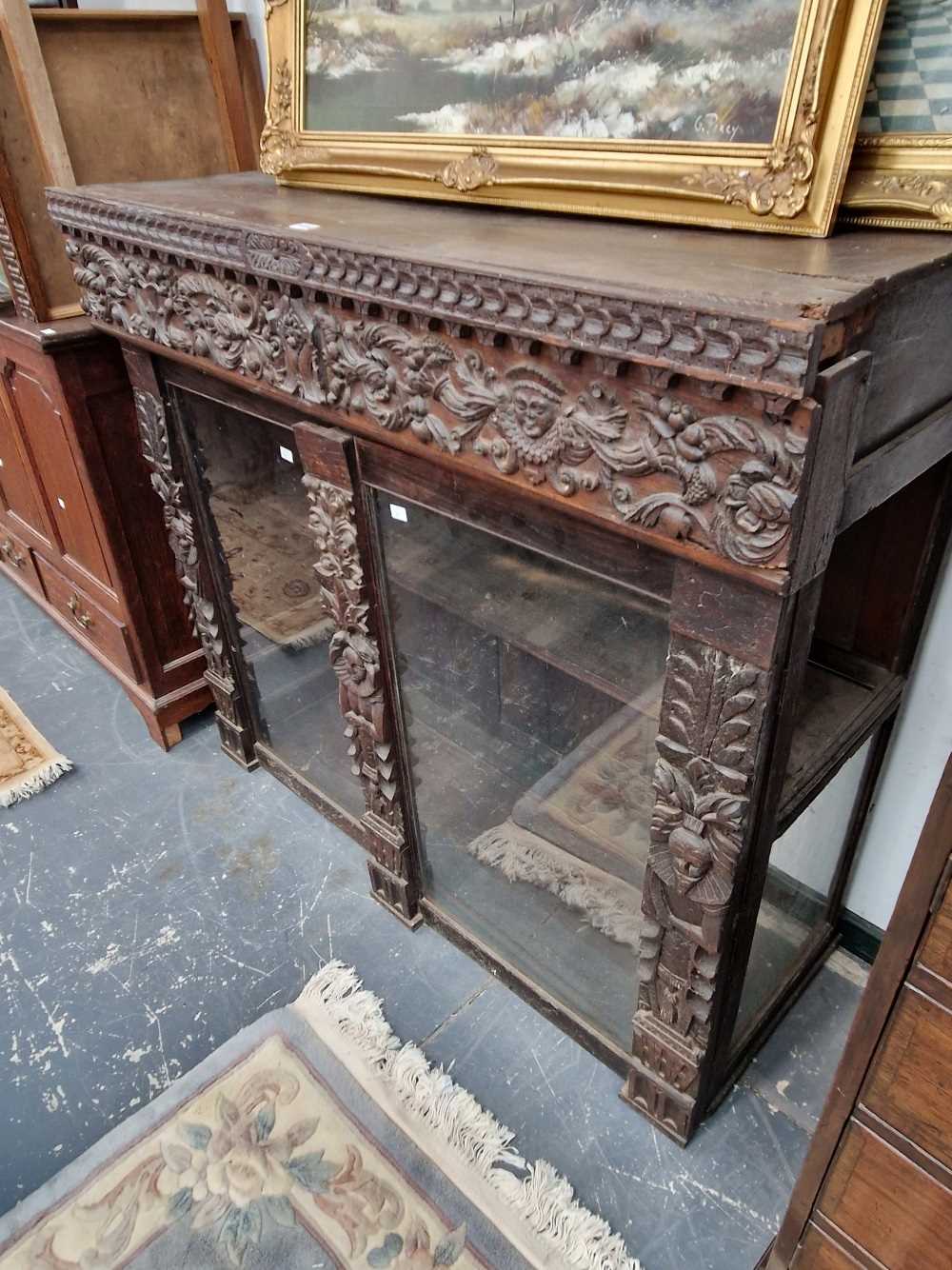 A carved oak glazed cabinet.