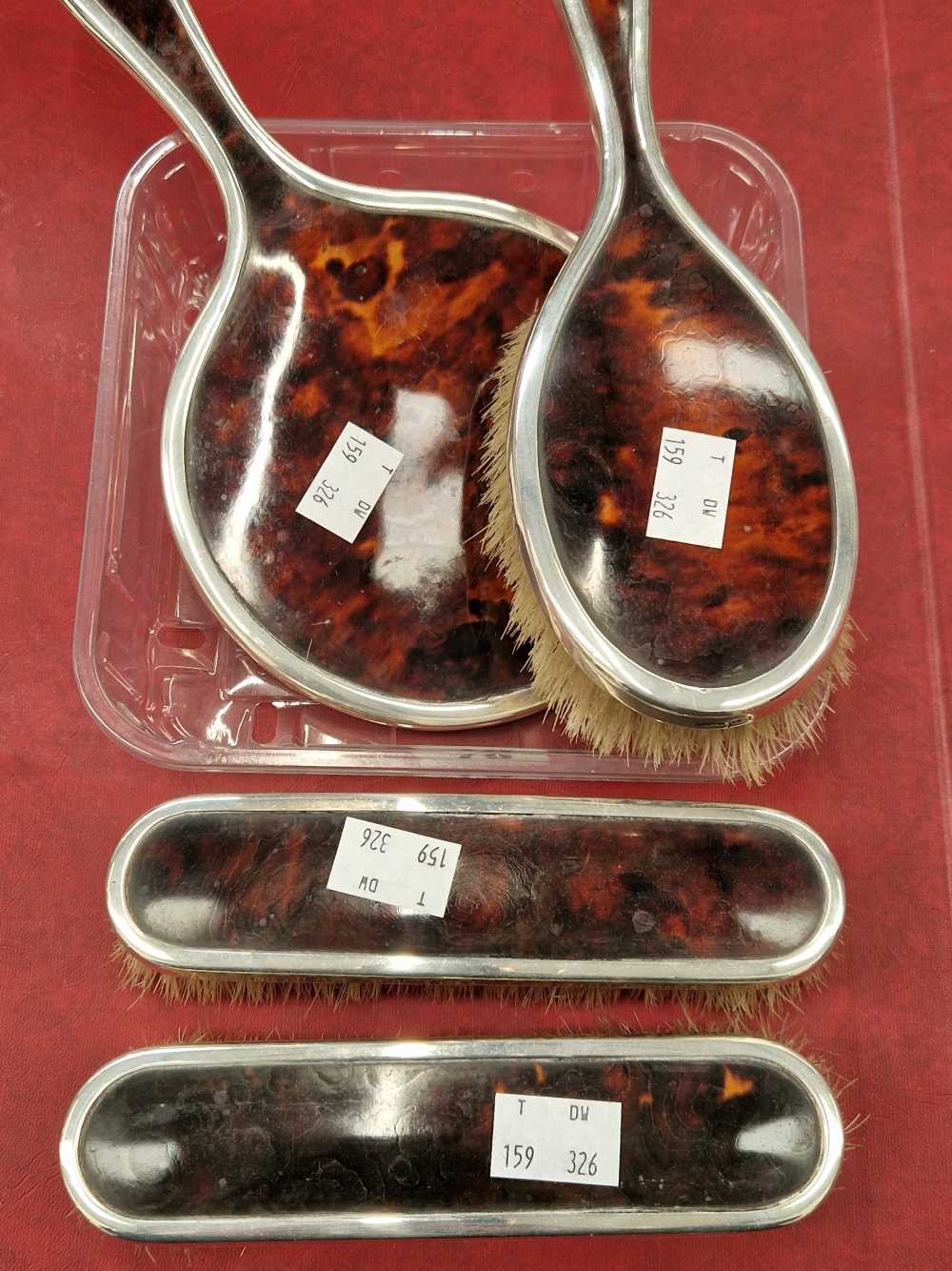 A hallmarked silver and tortoise shell four piece brush and mirror set.