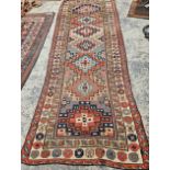 AN ANTIQUE CAUCASIAN TRIBAL RUNNER 304 x 114 cm.