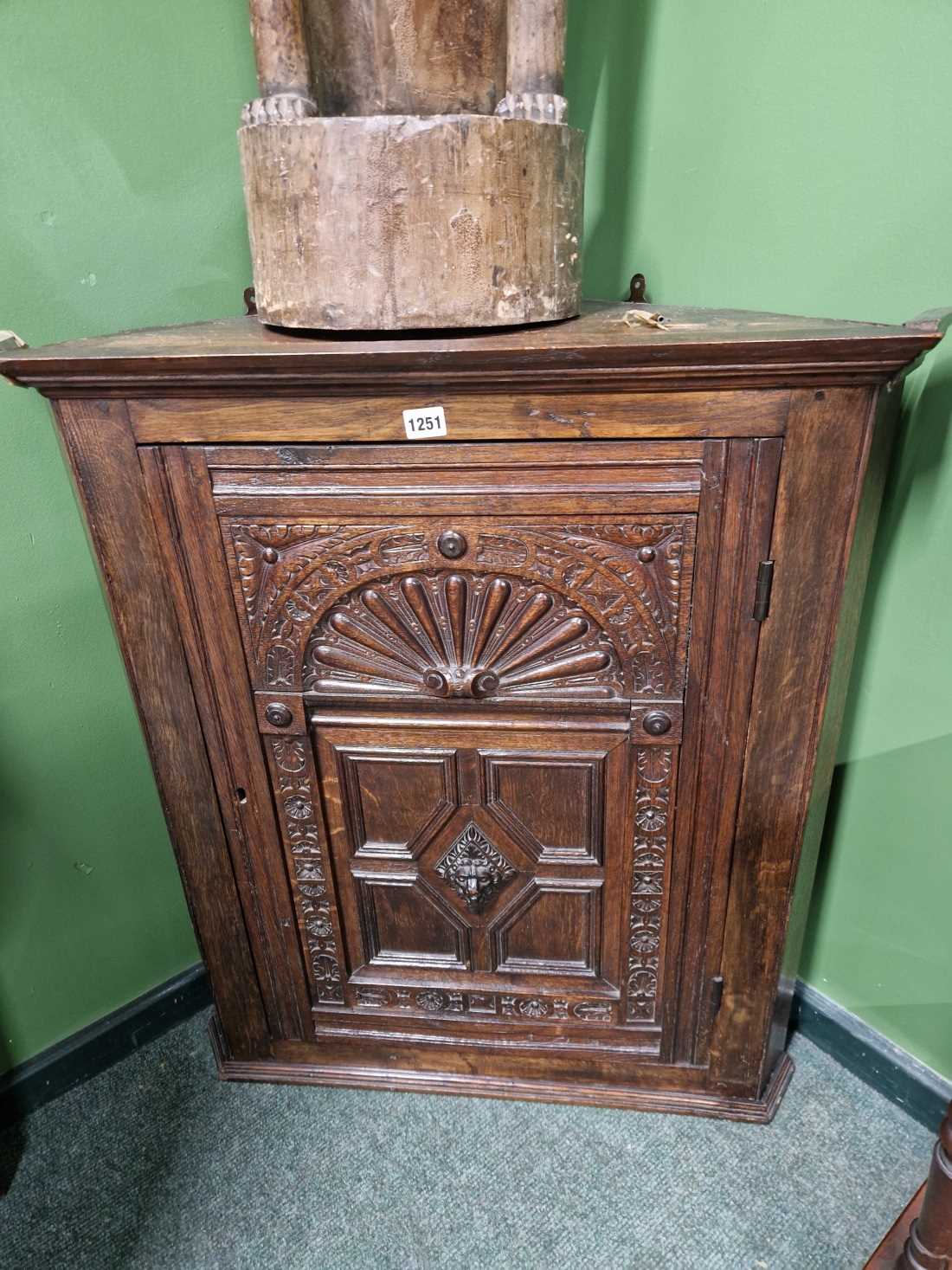 A carved oak corner cabinet.