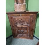 A carved oak corner cabinet.