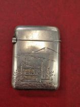 A Japanese silver vesta case with pagoda and mountain decoration. Character signature to reverse.