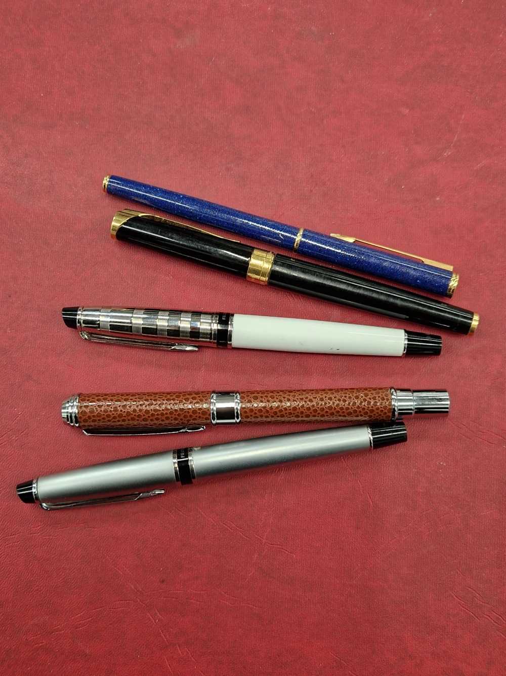 Four Waterman fountain pens and one other.