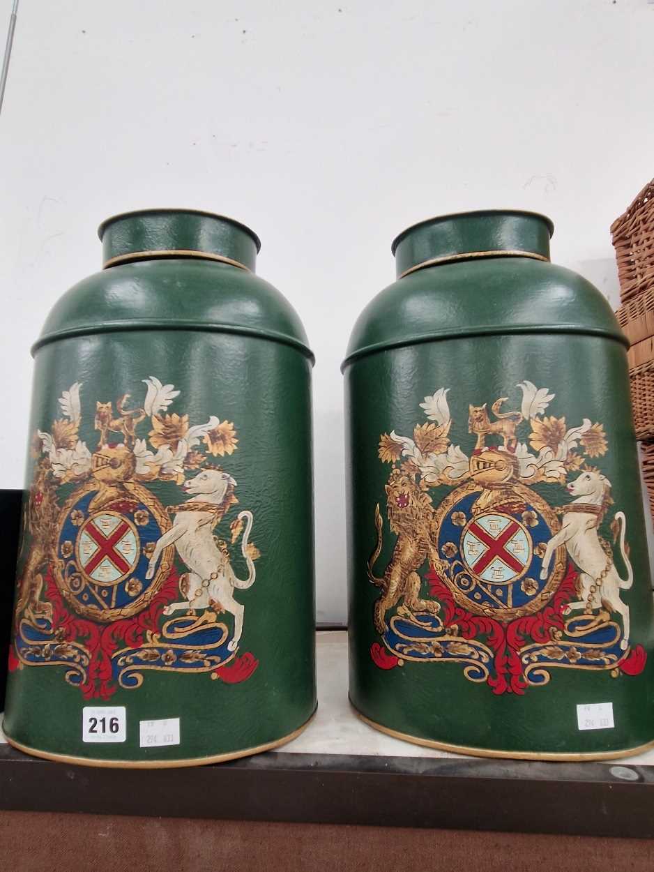 A pair of green painted tole tea cannisters, each with an armorial