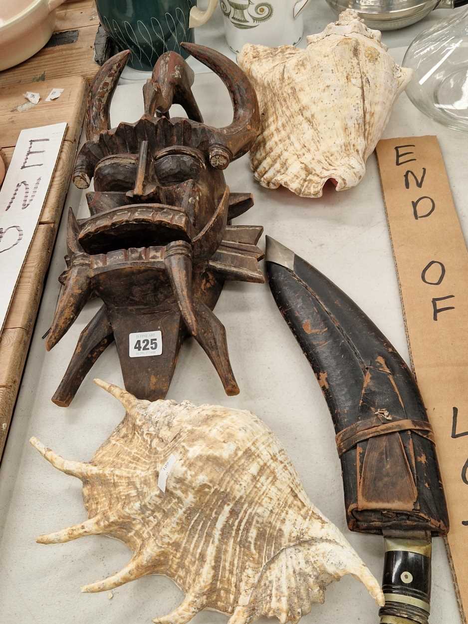 A kukhri, two conch shells and a tribal wooden mask