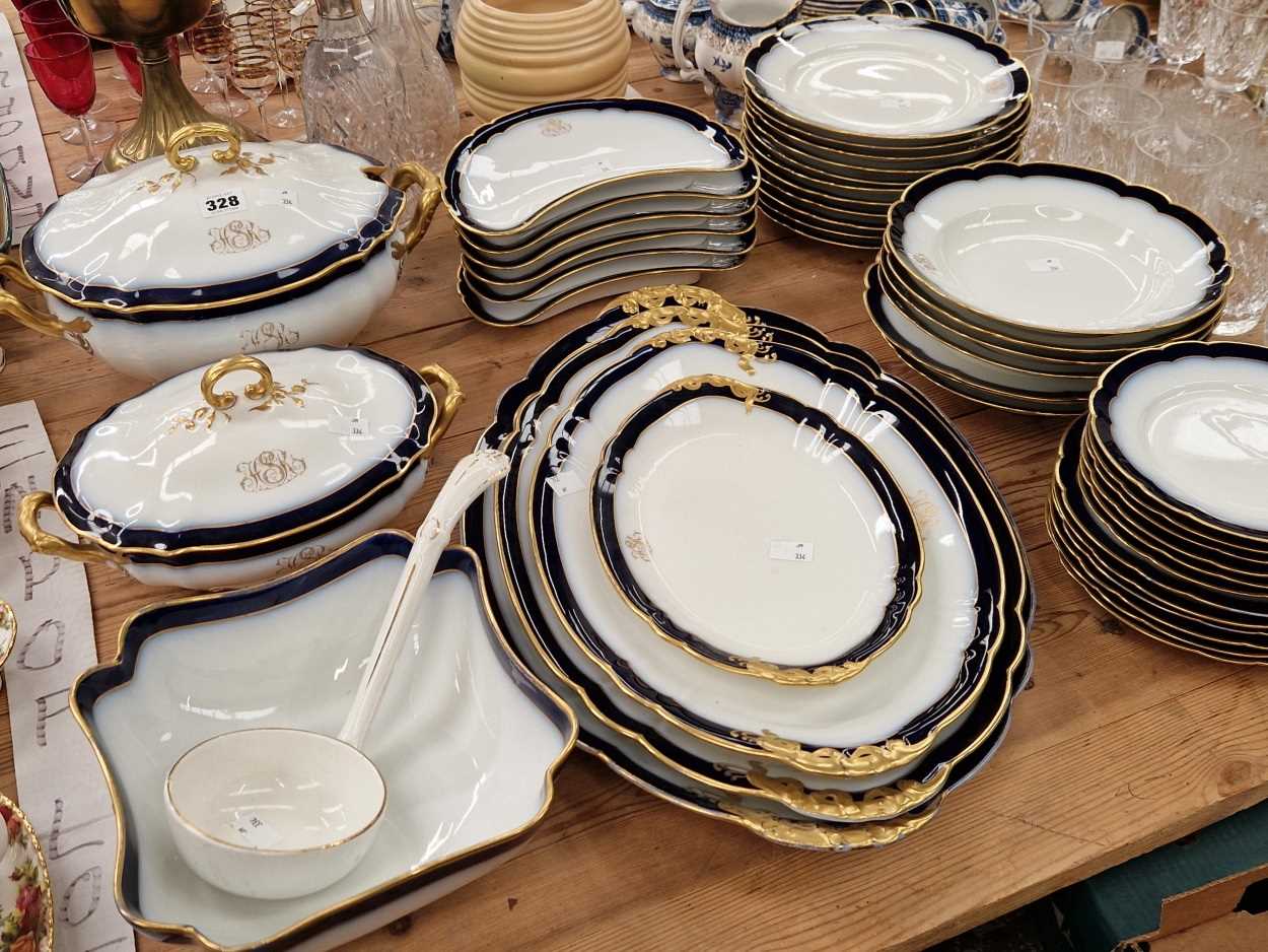 A gilt monogrammed Limoges dinner service, each piece edged with blue and gilt bands