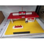 An Esso toy garage mounted on a yelloow board