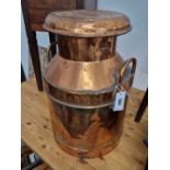 A vintage copper milk churn.