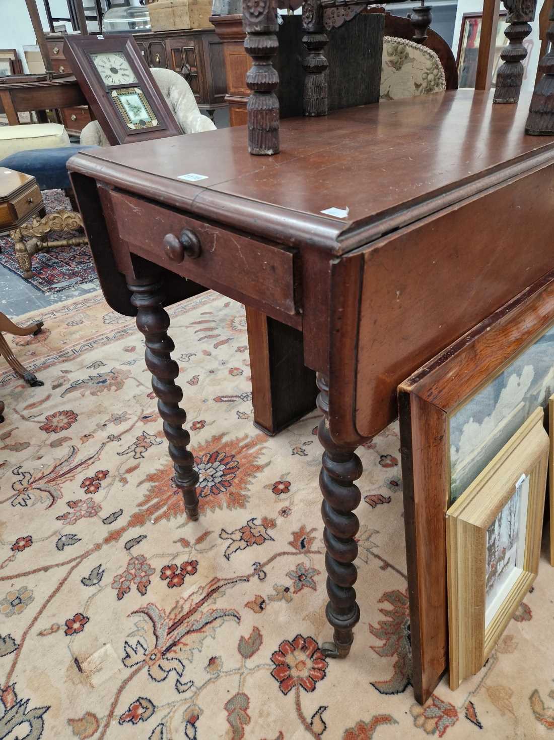 A Victorian Pembroke table on barley twist legs.