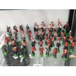 A collection of Britains lead bandsmen figures marching on green bases