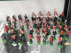 A collection of Britains lead bandsmen figures marching on green bases