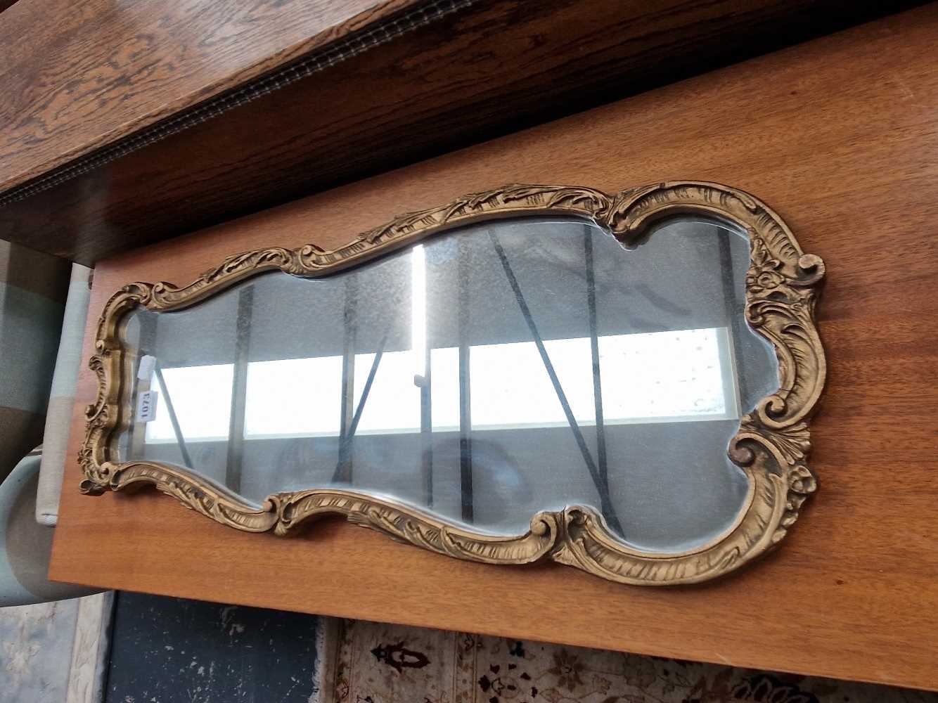 A gilt framed mirror. H 71cms Widest width 28cms narrowist width 20cms