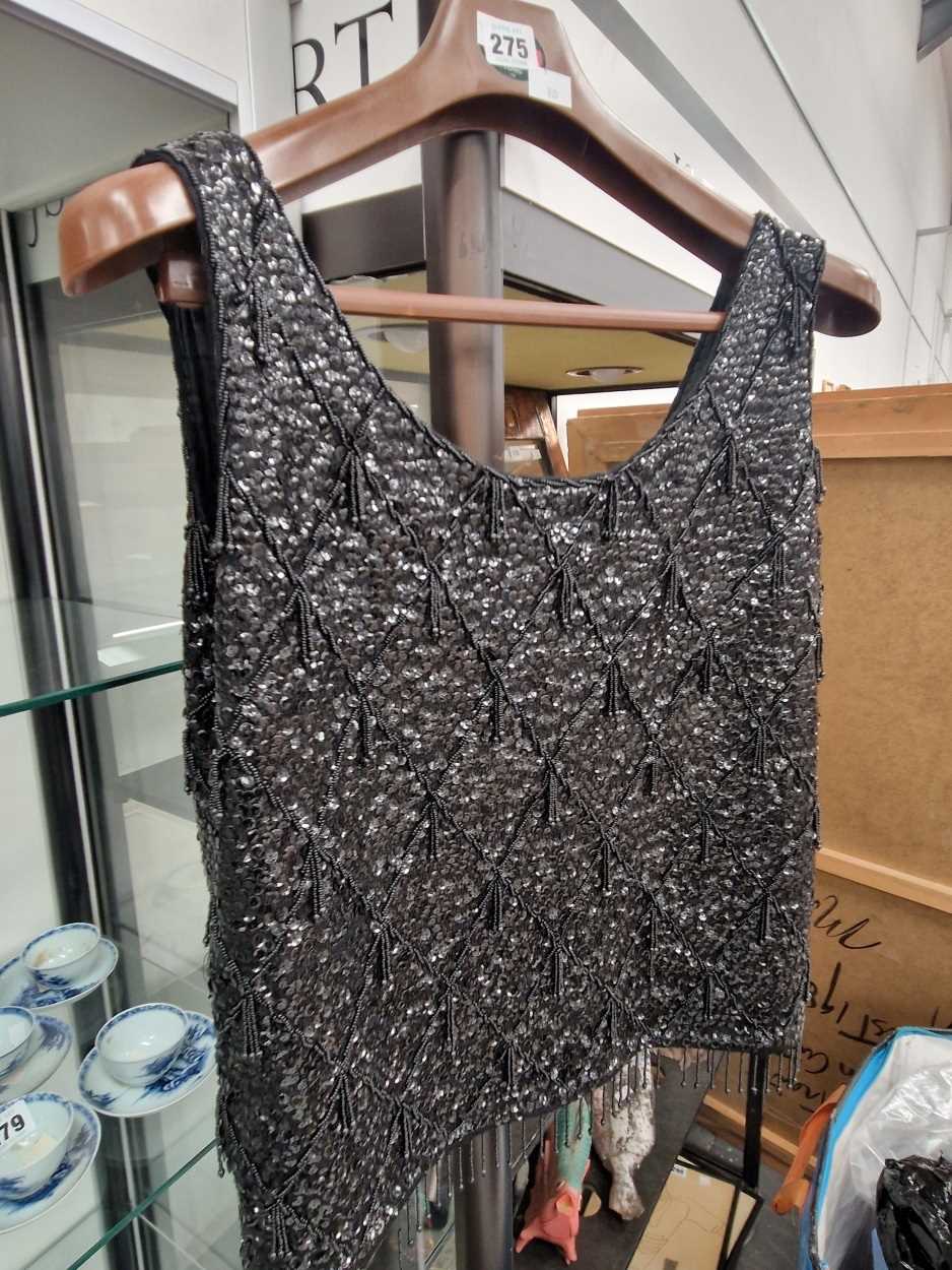 A lady's black sleeveleass top sewn with sequins together with a fur stole and muff