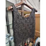 A lady's black sleeveleass top sewn with sequins together with a fur stole and muff