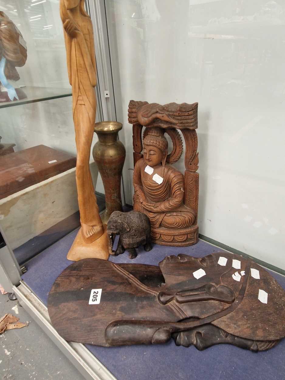 A carved wood Buddha, a pair of African  head and shoulder wall plaques, a carved wood standing