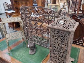 A cast iron room heater, a fire guard, door stop and a brass two tier stand.