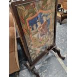 A Victorian fire screen with glazed tapestry panels.