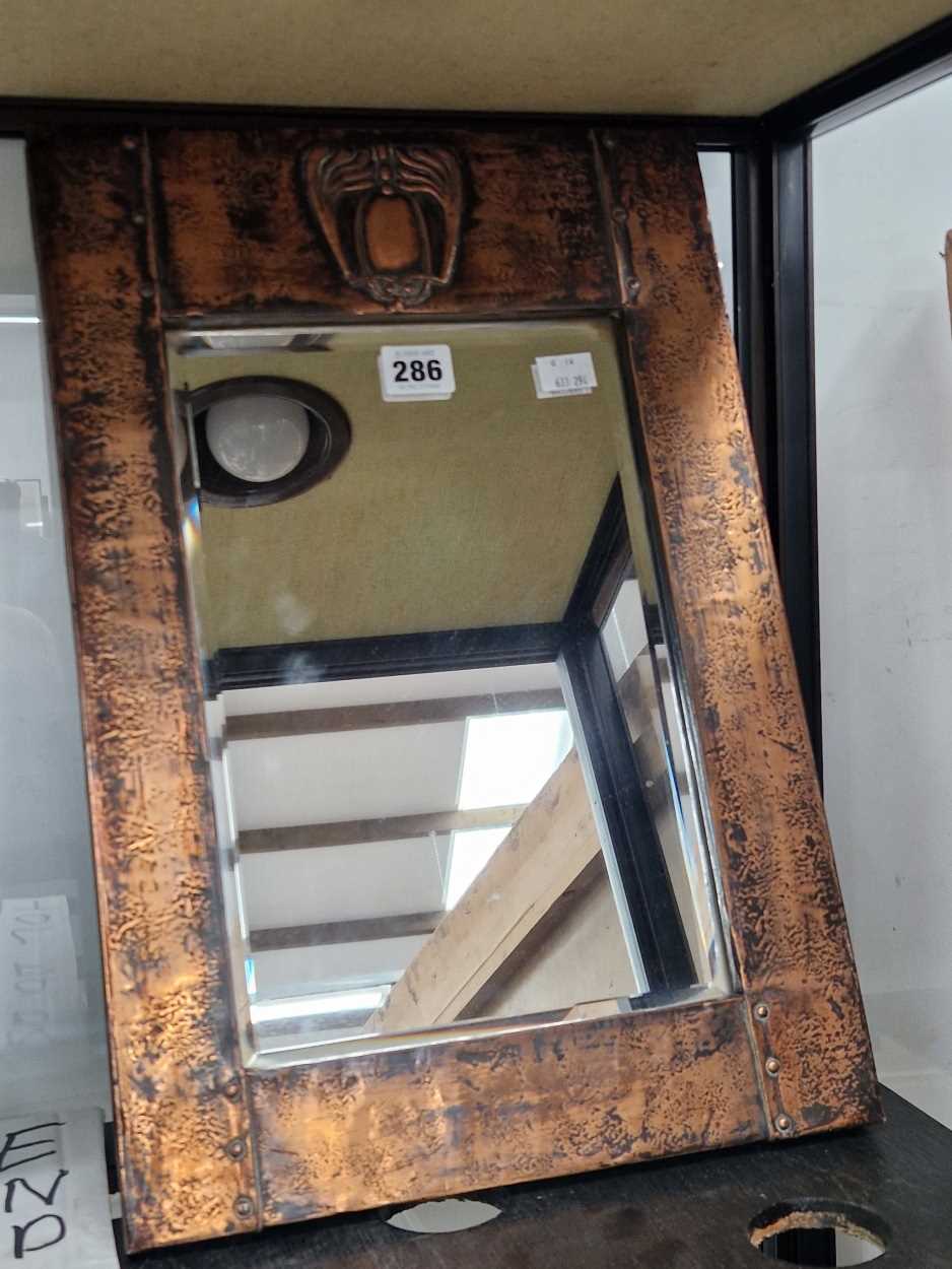 An Arts and Crafts copper framed bevelled glass rectangular mirror