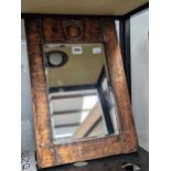 An Arts and Crafts copper framed bevelled glass rectangular mirror