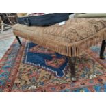 A vintage lonh footstool with carpet upholstery.