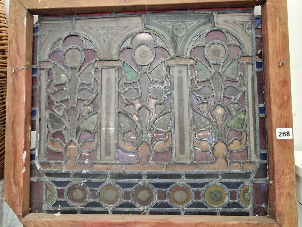 A pine framed leaded glass panel of three arches of flowers between columns