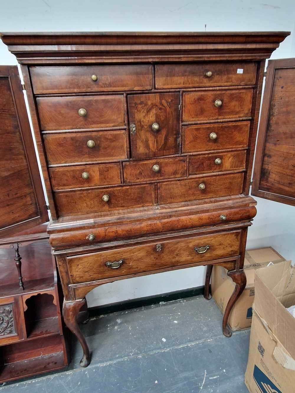 An 18th century walnut cabinet on stand. The top left corner of the cornice is chipped and there