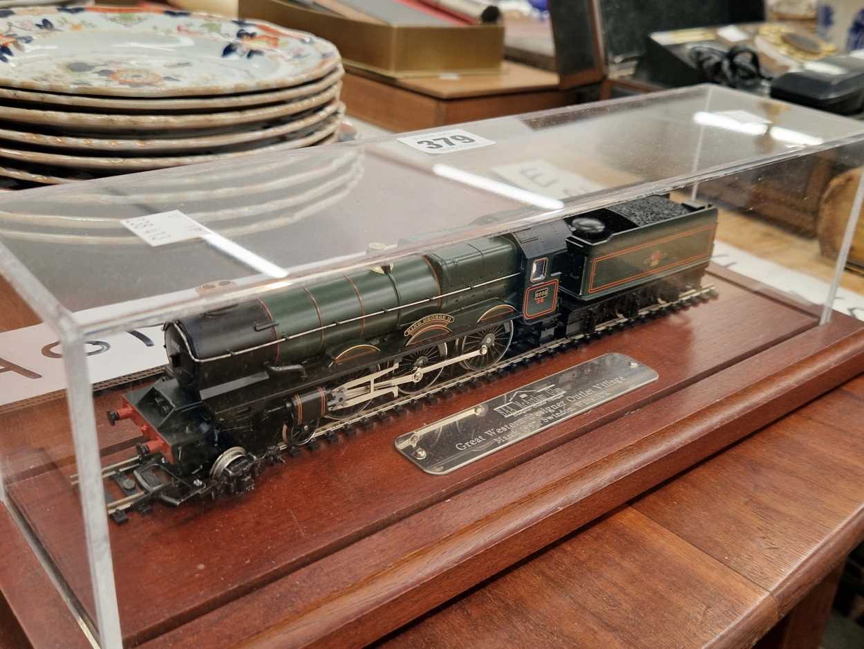 A Designer Outlet scale model locomotive and tender in a perspex case