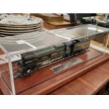 A Designer Outlet scale model locomotive and tender in a perspex case