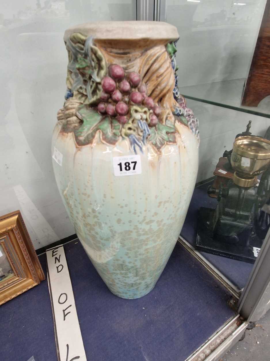 A Mougin pottery vases moulded with flowers and grapes about its neck