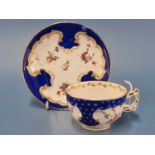 A Chelsea Derby tea cup, the blue rim gilt with stars, the moulded scrolls enclosing flowers in