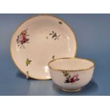 A Derby tea bowl and saucer painted with sprays of flowers within gilt dentil rim lines, blue marks,