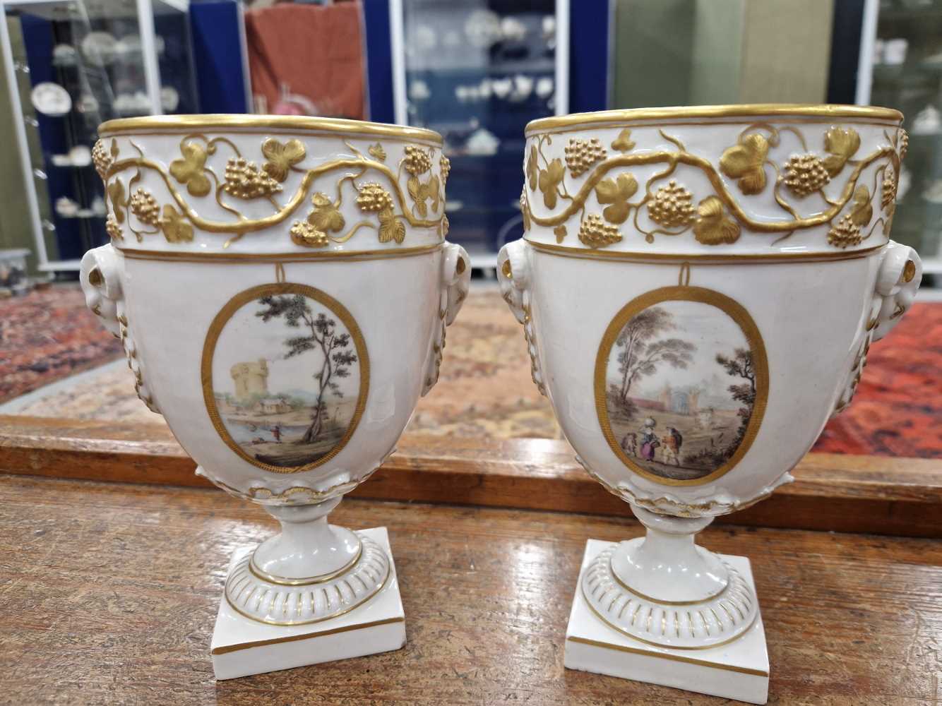 A pair of Derby ram handled vases supported on square feet painted with landscapes by Askew or - Image 7 of 17