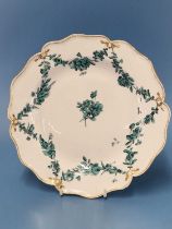 A Derby plate painted with green floral swags within a gilt dentil line on the wavy rim, RF 126 This