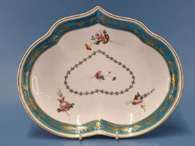 A Derby kidney shaped dish painted with a turquoise rim band gilt with grapes and enclosing four