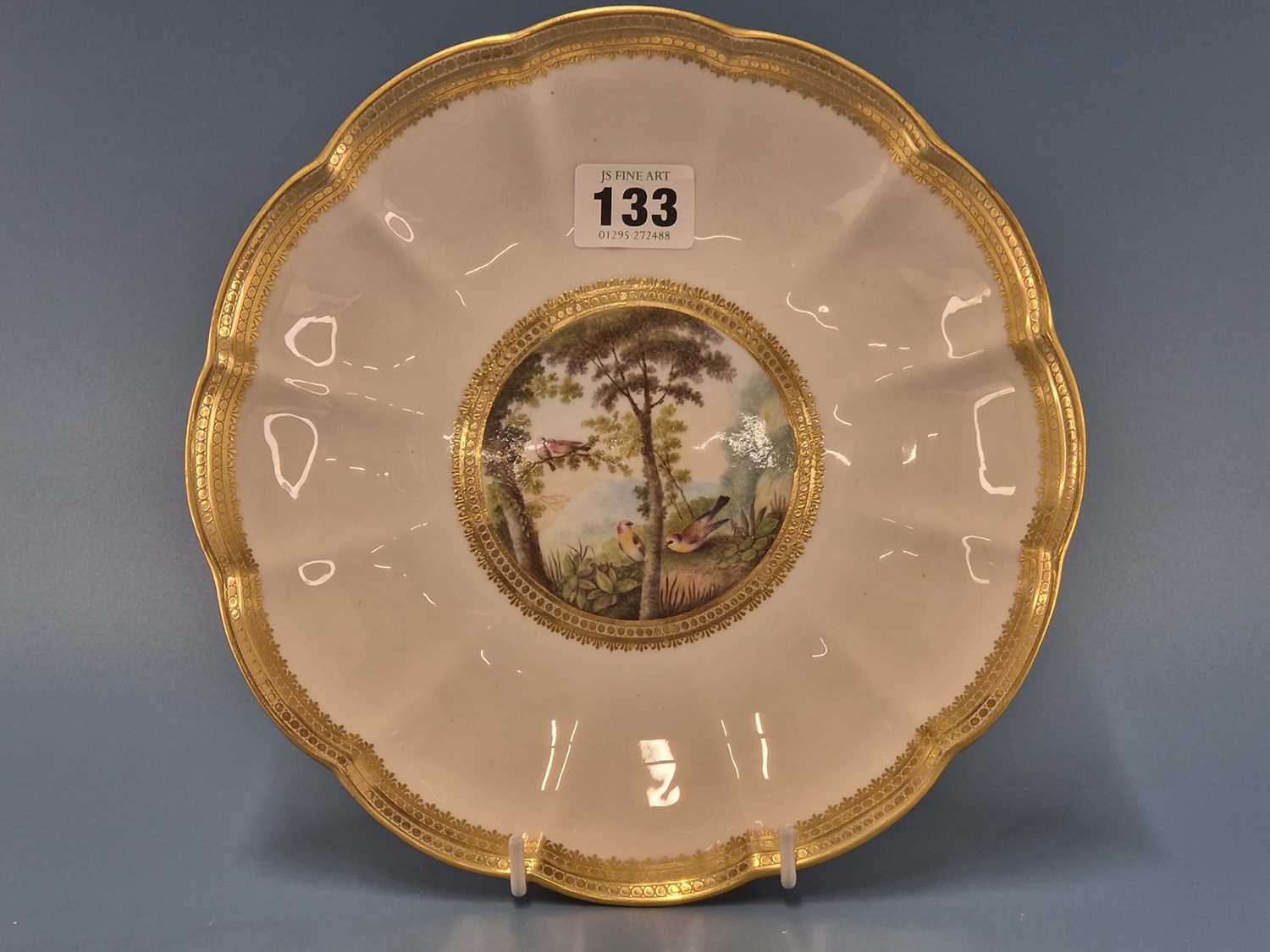 A Derby plate painted by George Robertson with birds in a landscape within a gilt wavy edged rim,