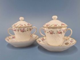 A pair of Derby two handled cups, covers and stands, wheat ear moulded and painted with chains of