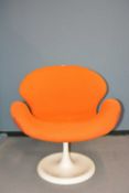 A mid 20th C. orange upholstered swivel armchair on a white circular foot