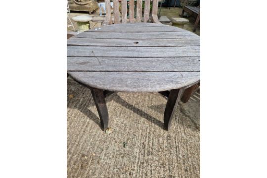 A teak circular garden table.