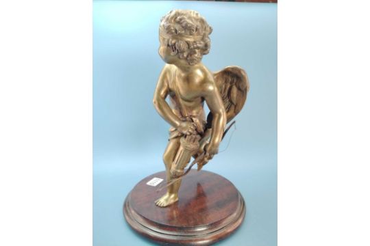 A bronze figure of Cupid reaching for an arrow from his quiver, with a wood stand.   H 28cms - Image 2 of 9