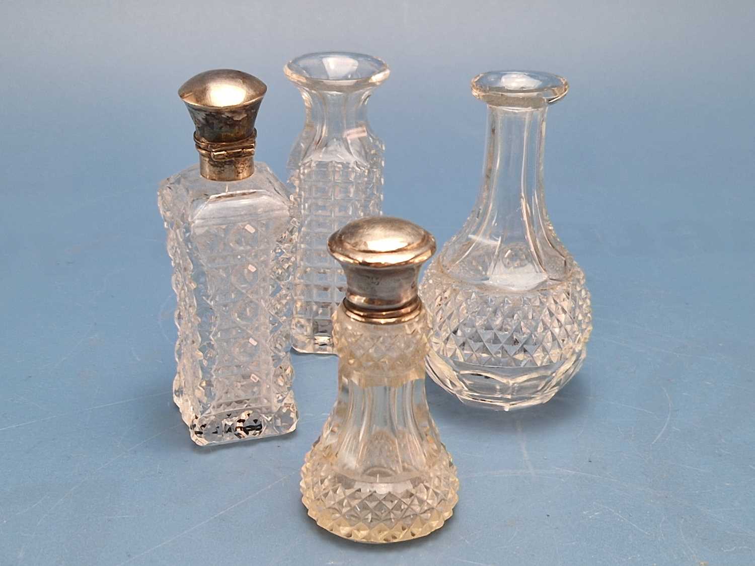 A London and a Chester silver capped cut clear glass scent bottle together with two without