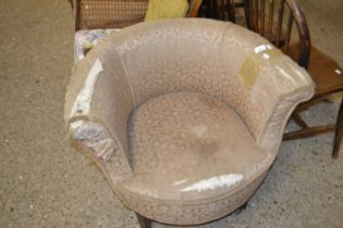 A tub armchair on wooden caster feet, distressed