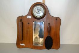 A hall mirror in wooden frame complete with two brushes and barometer at the top