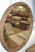 Oval mirror in gilt scroll frame