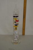 A glass cylindrical vase with other small vase decoration