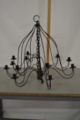 A metal hanging light fitting with candle sconces