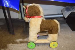 A pull-along toy horse on wheels